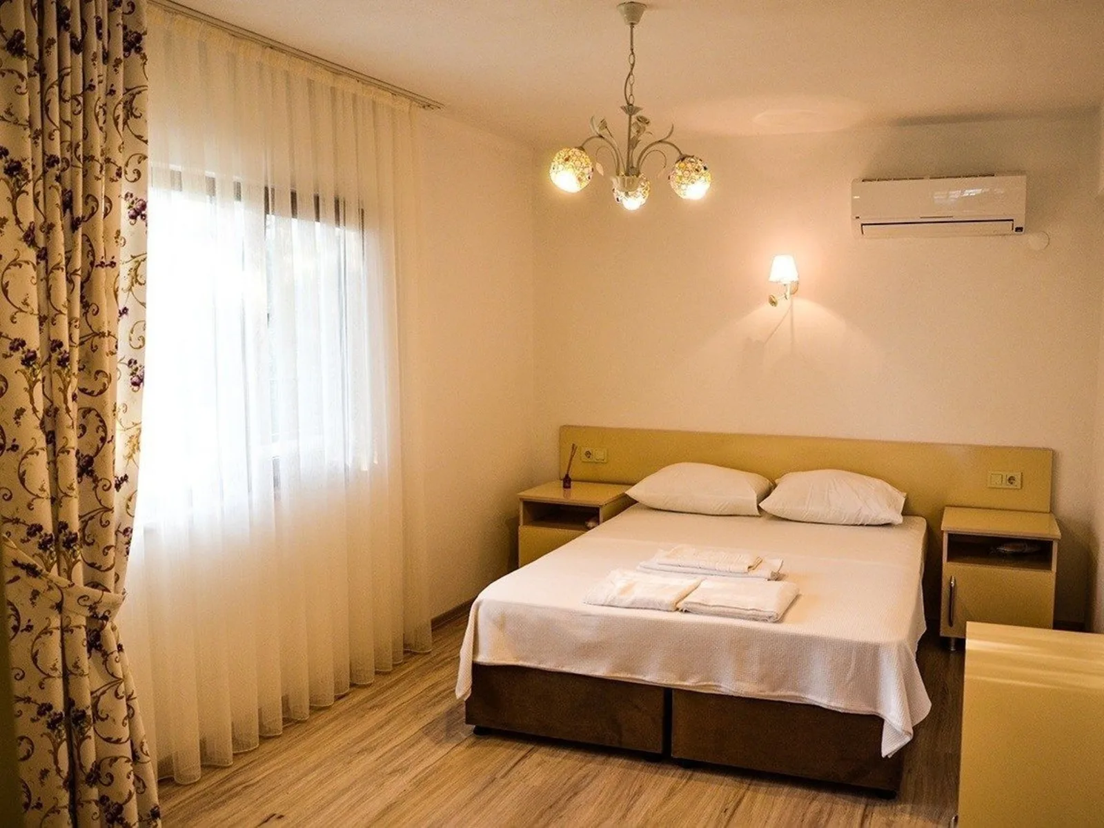 The suite: a bright room with a chandelier, double bed and sitting area