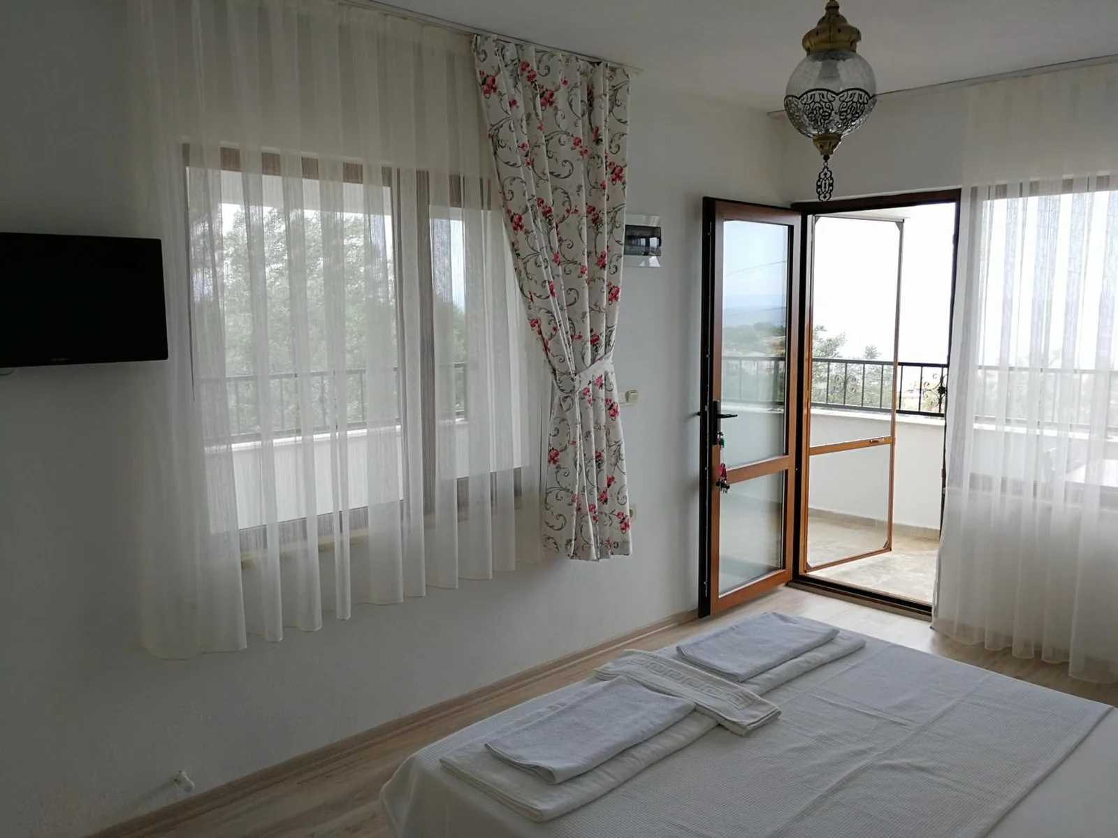 The triple room: television, balcony door and two beds